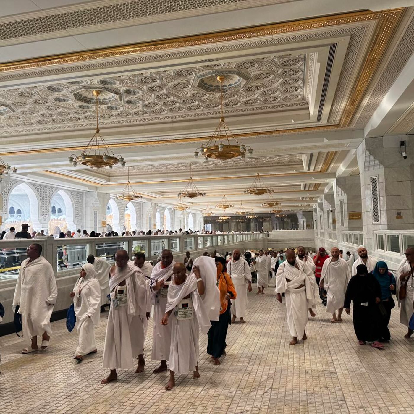 Pilgrims walking through the Grand Mosque corridor