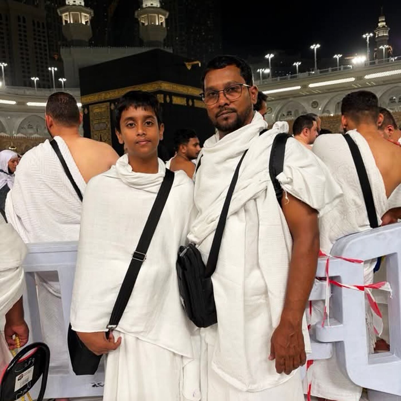 Father and son pilgrims at the Kaaba at night